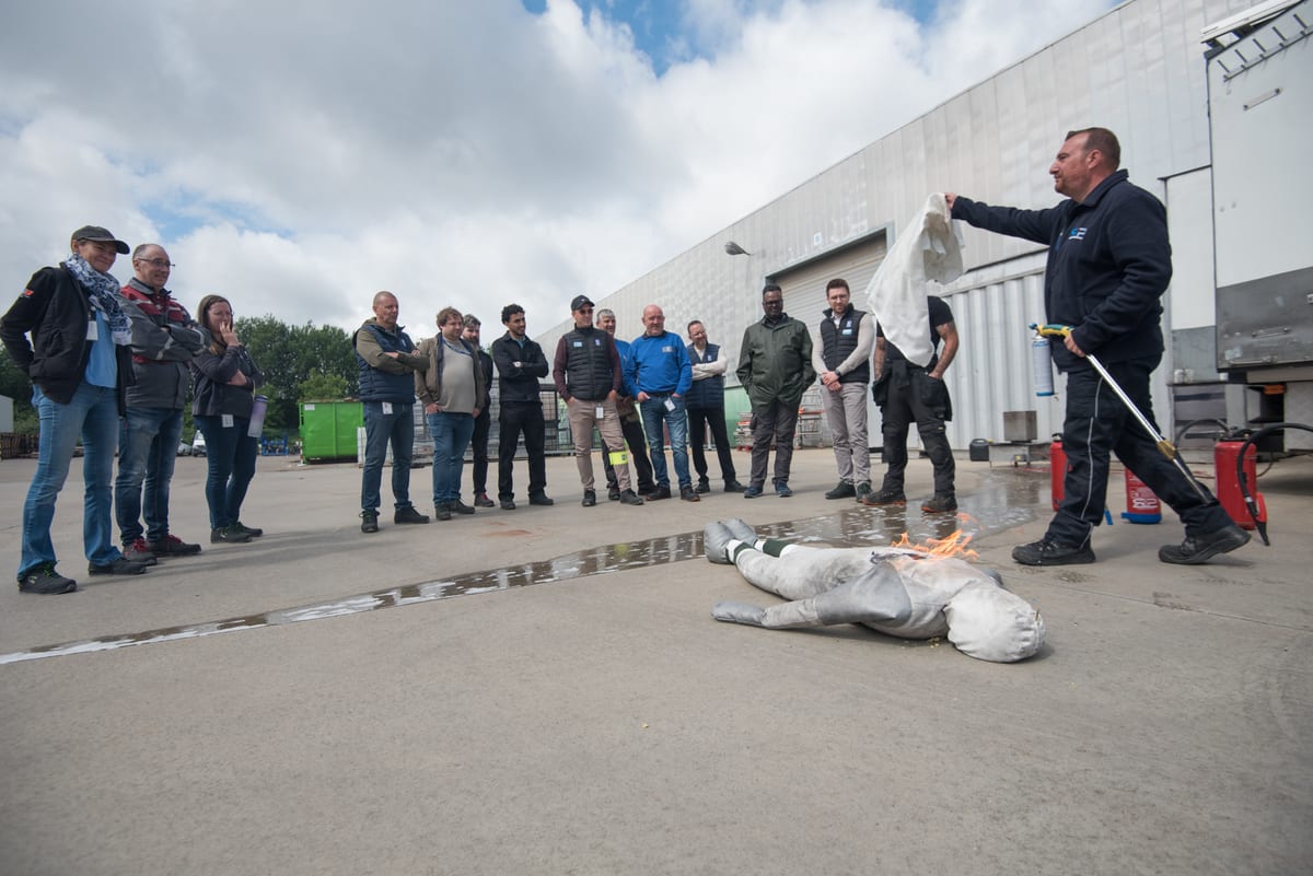 Exercice d'extinction d'incendie en extérieur devant un groupe de salariés attentifs