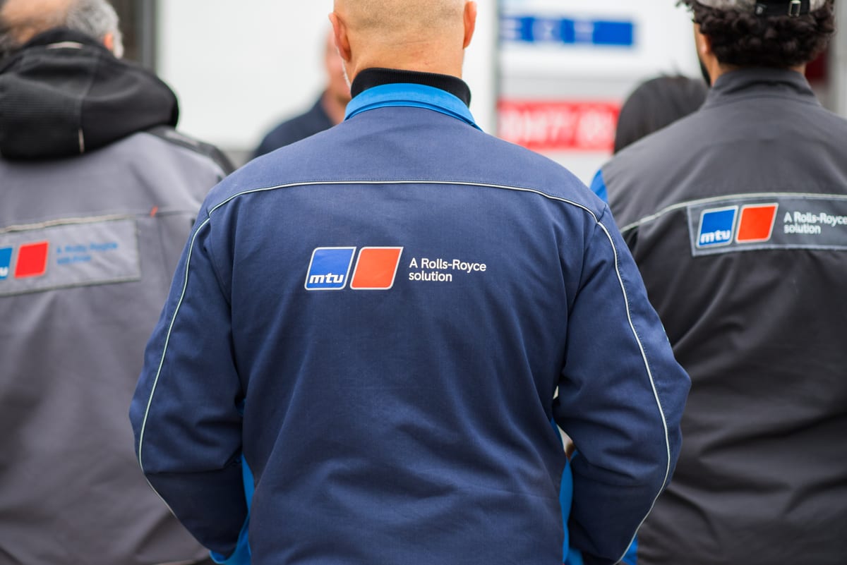 Techniciens de dos en veste de travail lors d'une présentation industrielle en extérieur