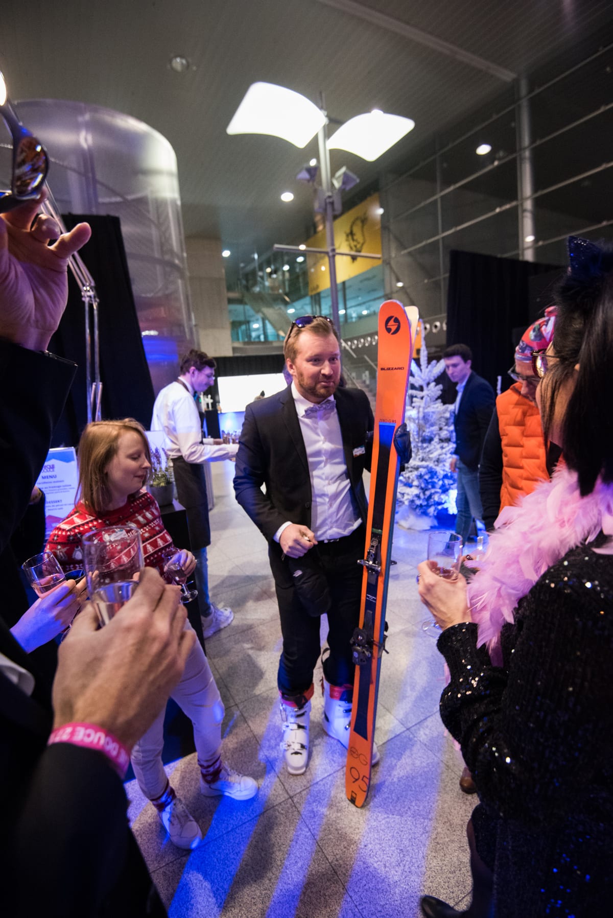 Invité en costume tenant une paire de skis lors d'une soirée d'entreprise sur le thème de l'hiver