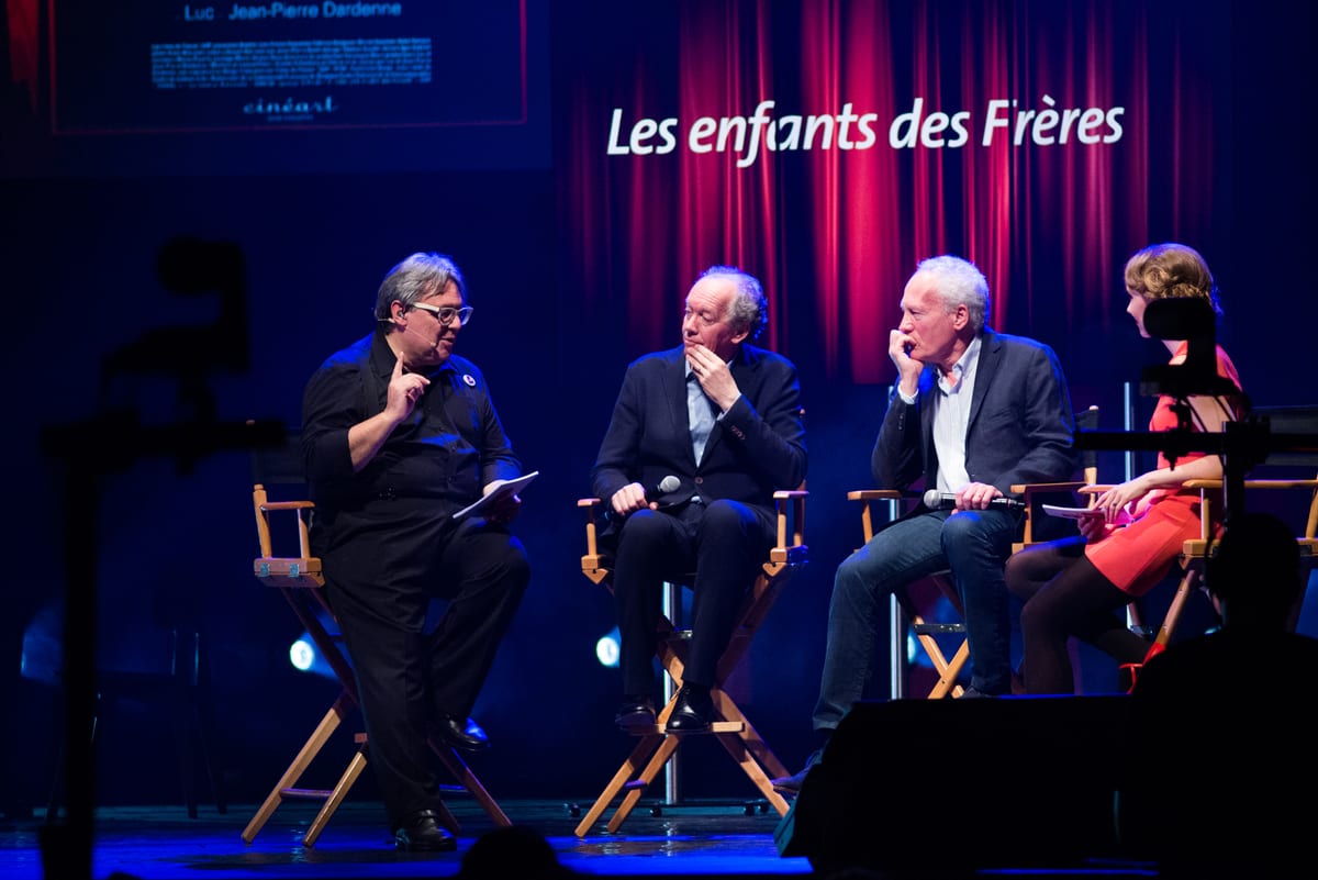Table ronde de quatre intervenants en fauteuils de réalisateur sur la scène d'un festival de cinéma